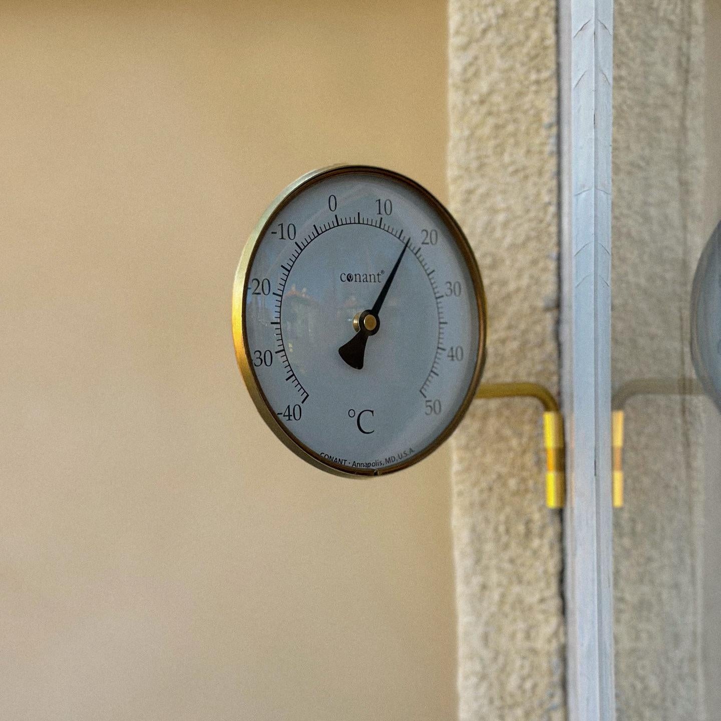 Termometer i mässing från Conant som sitter utanför ett fönster
